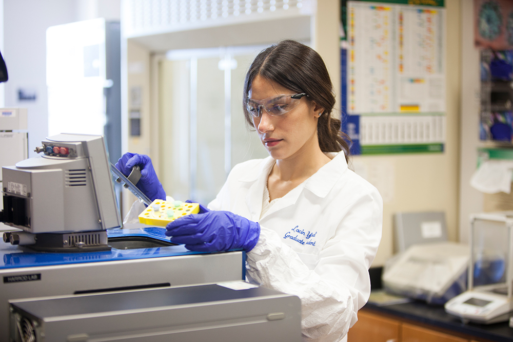 A faculty researcher works with a pipette in an SMU lab 
