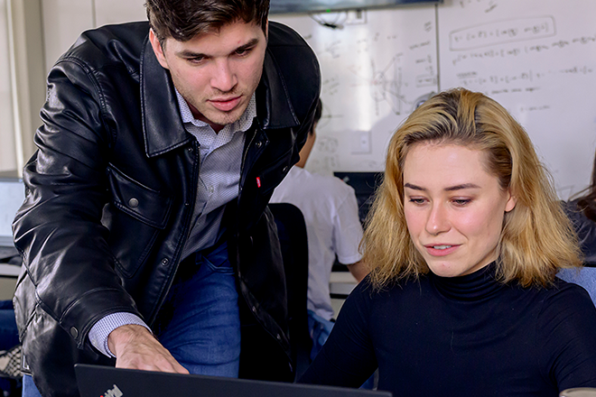 SMU Guildhall production student works with team member in class