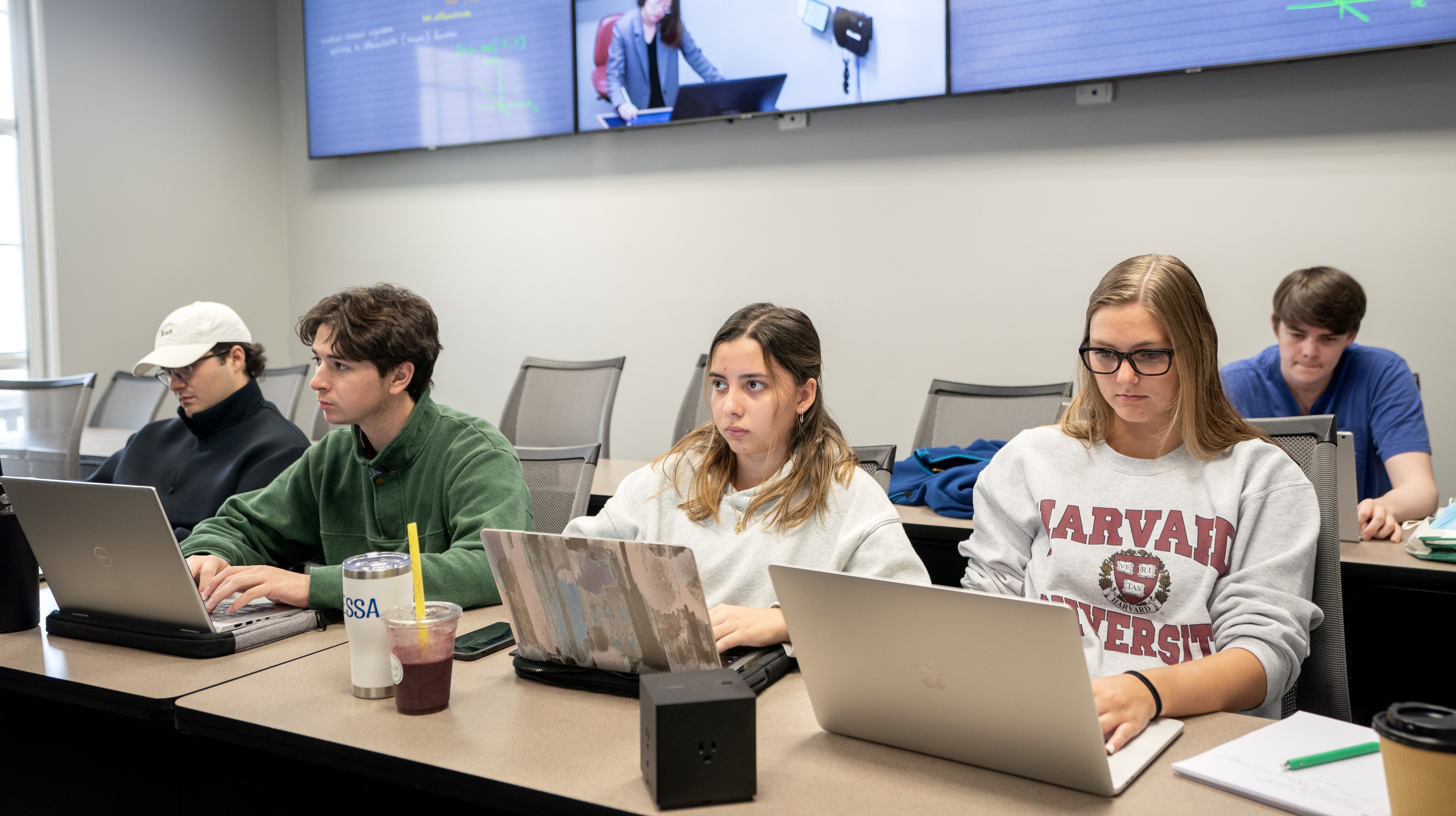 Students sitting in a classroom using laptops.