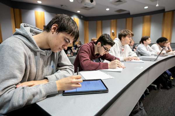 Students at long desk in classroom