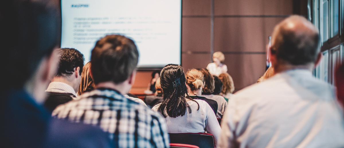 People sitting in a class photographed from behind.