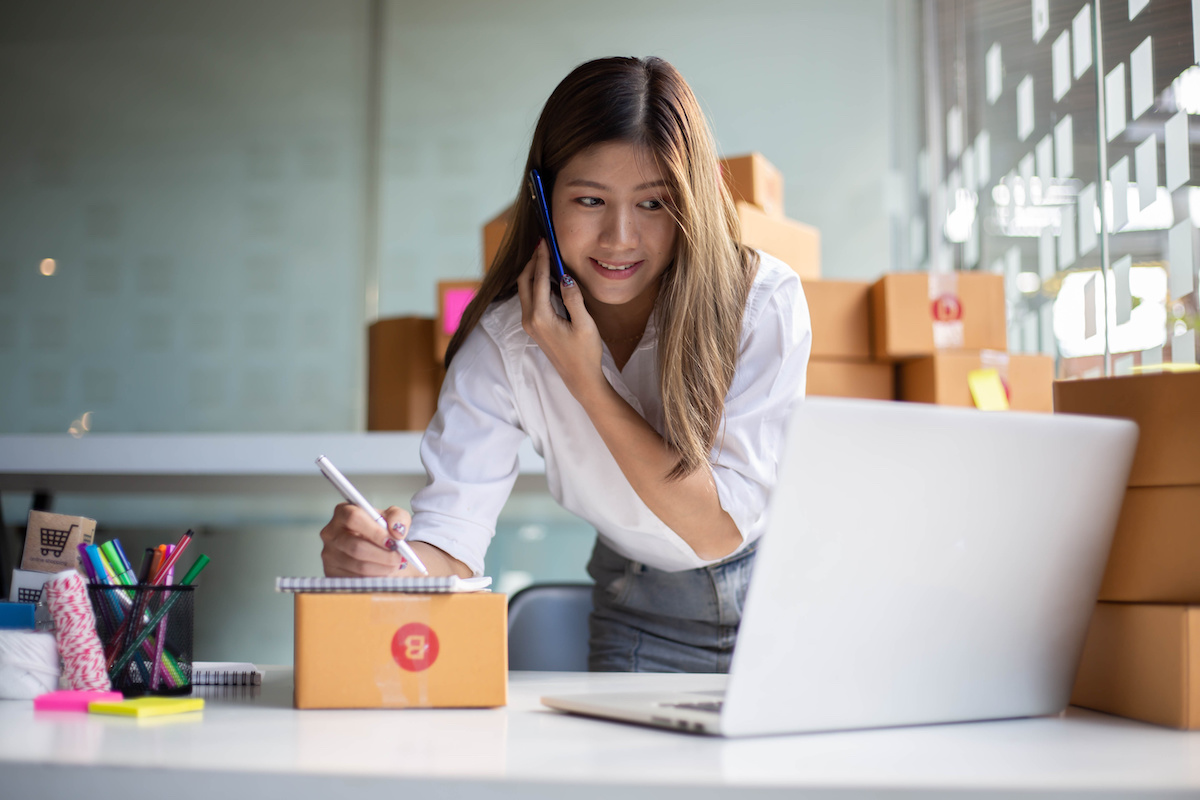 Woman on the phone surrounded by boxes