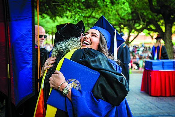 Graduate hugging faculty member