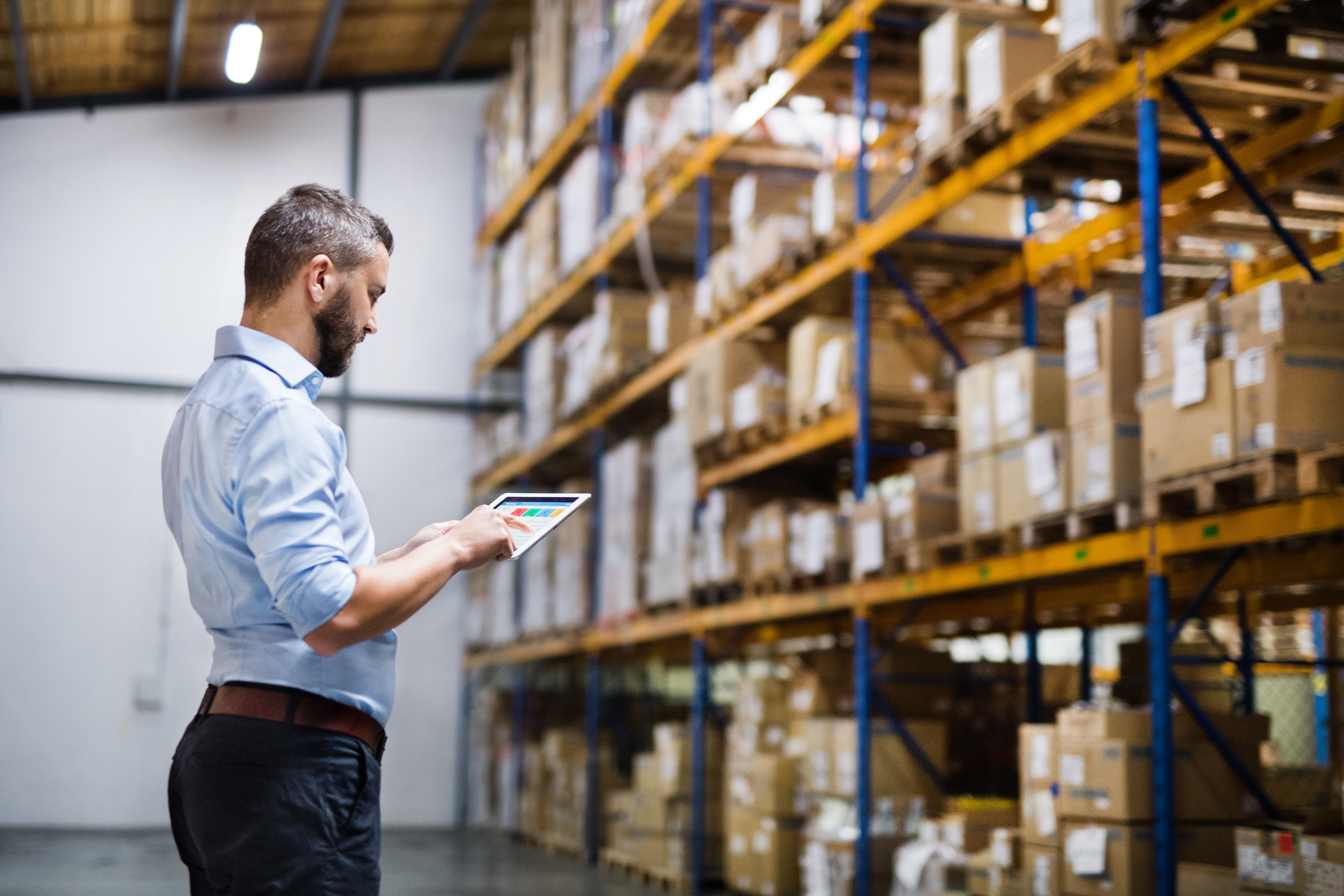 Photo of man in front of warehouse inventory