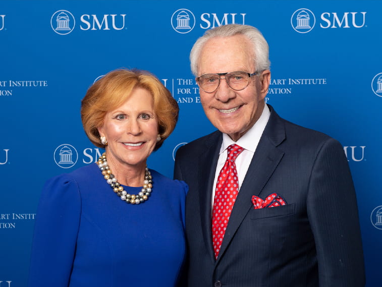 Linda-Wertheimer-Hart-and-Milledge-Mitch-A.-Hart-III standing against an SMU backdrop