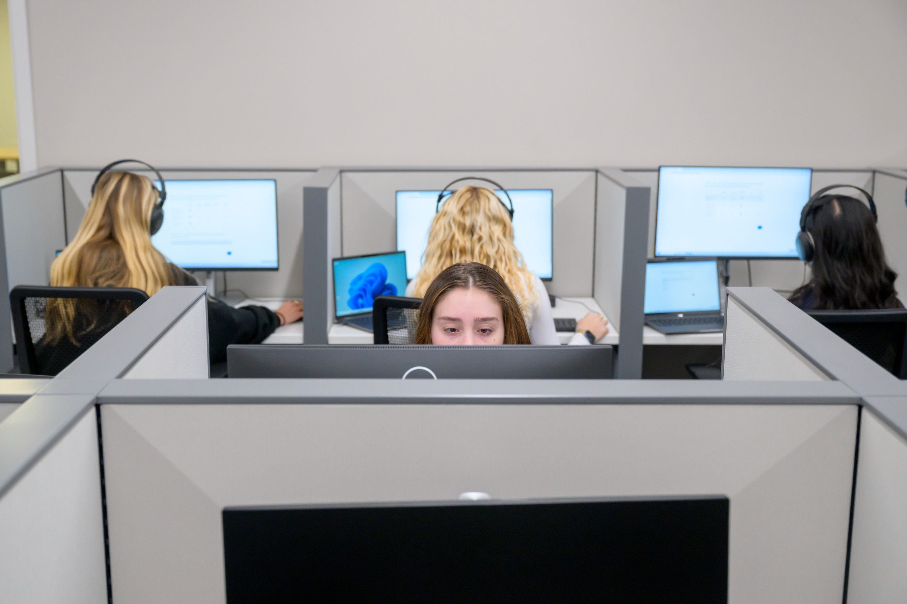 Students sit at computers and wear over-the-ear headphones in the Cox Behavioral Lab