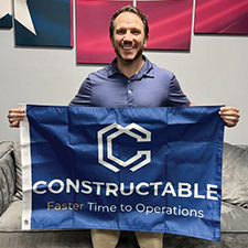 Ryan Banko holds a flag that reads Constructable
