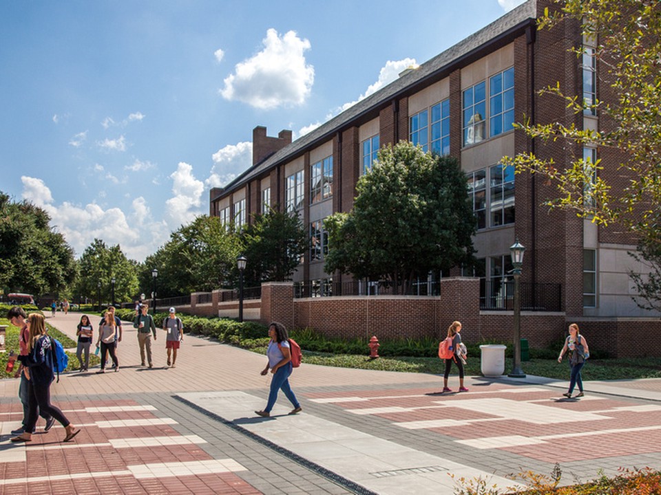 Student walk around the SMU Cox campus on a sunny day