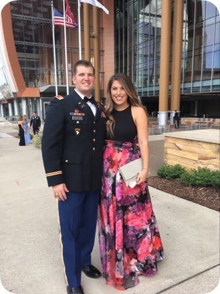 Bobby in his formal Army uniform poses in front of a windowed building