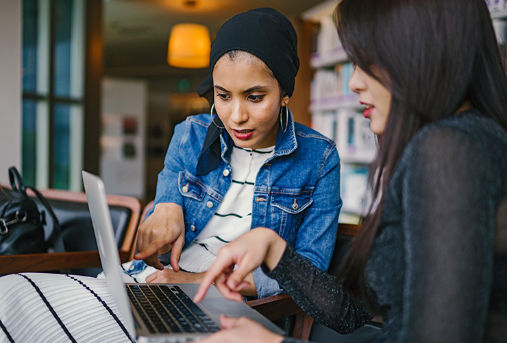 Two students using a laptop