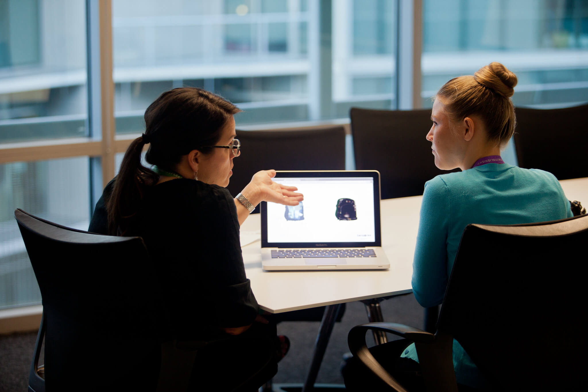 student and teacher at a desk looking at a computer screen