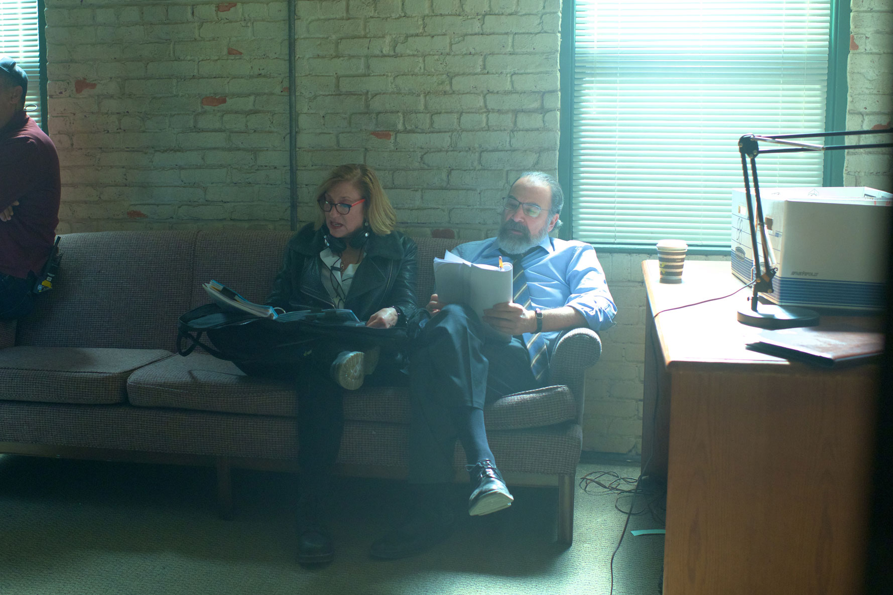 Lesli Linka Glatter goes over a script with an actor on set.