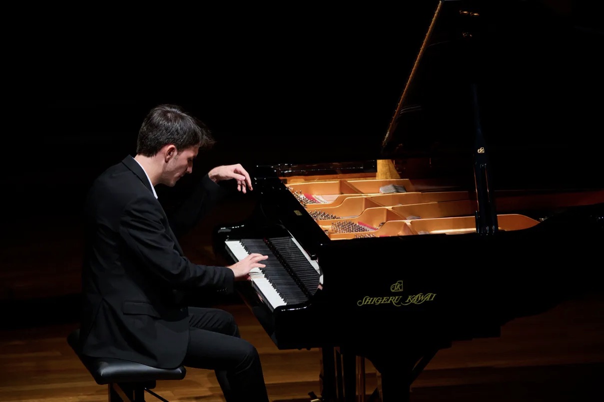 Artist Diploma student Can Saglam performs on the piano on stage