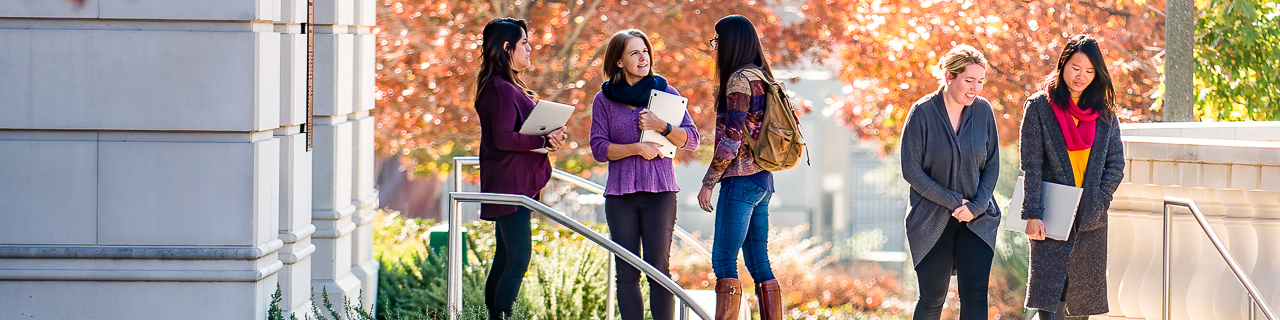 Dr. Paige Ware talks with students in the Simmons Quadrangle on a fall day. 