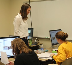 Professor overlooking student's work in classroom