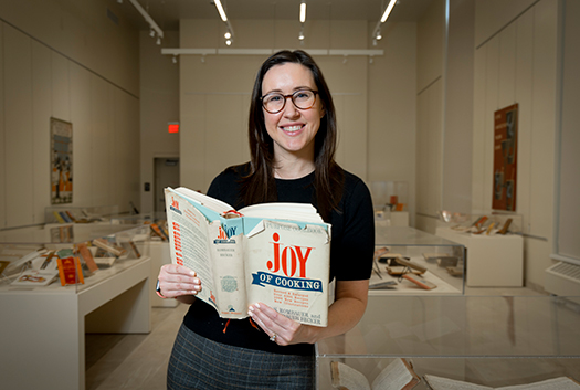 Photo of Christina Jensen holding a cookbook. 