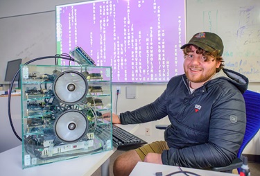 A photo of Conner Ozenne next to the "baby super-computer"