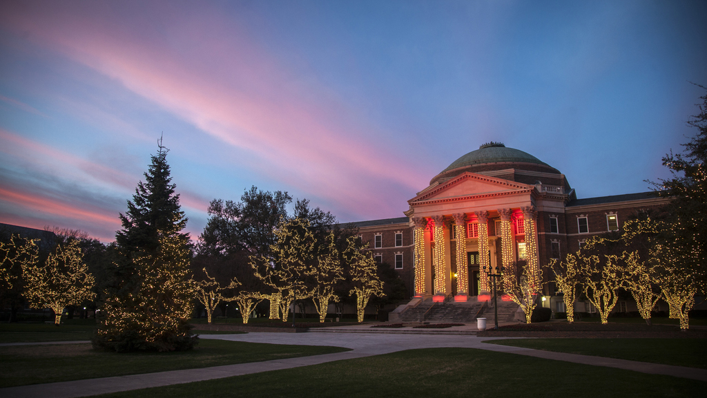 A photo of Dallas Hall decorated with holiday lighting.