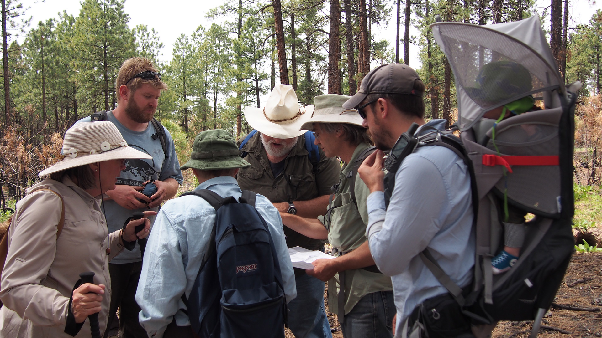 A photo of a group of people viewing a map together.