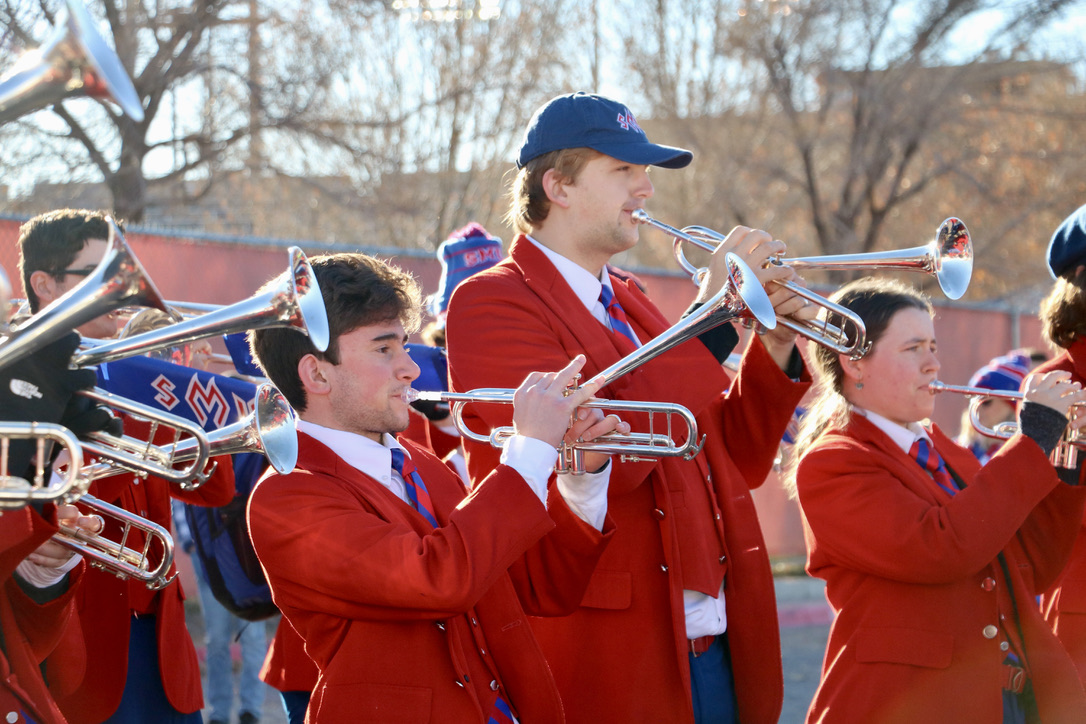 Mustang Band members playing trumpets outside