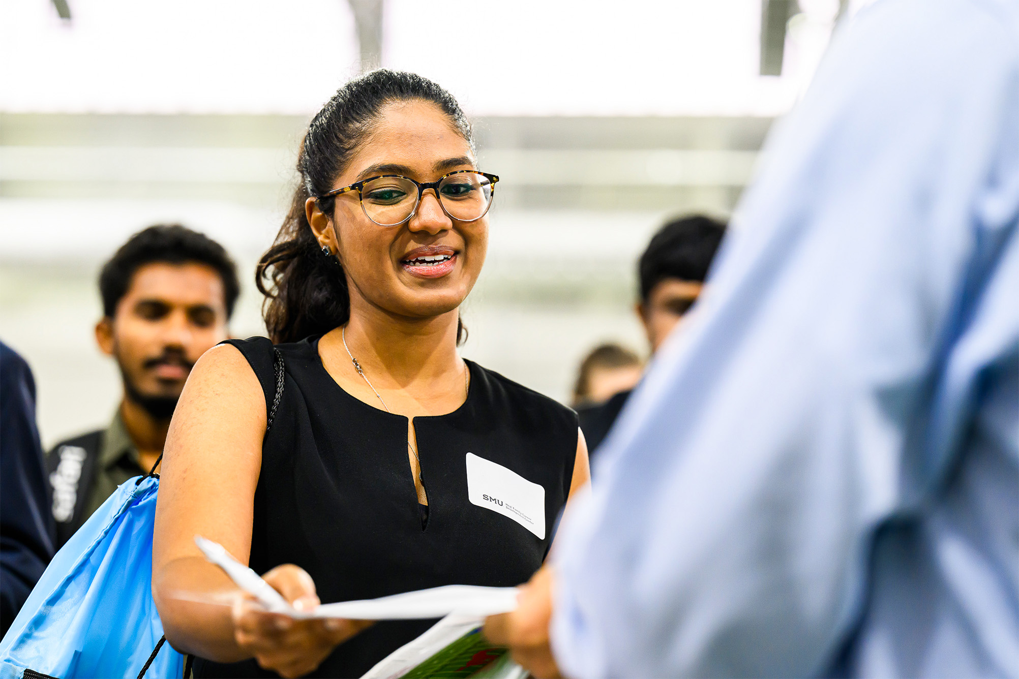 student handing piece of paper to employer at Career Fair