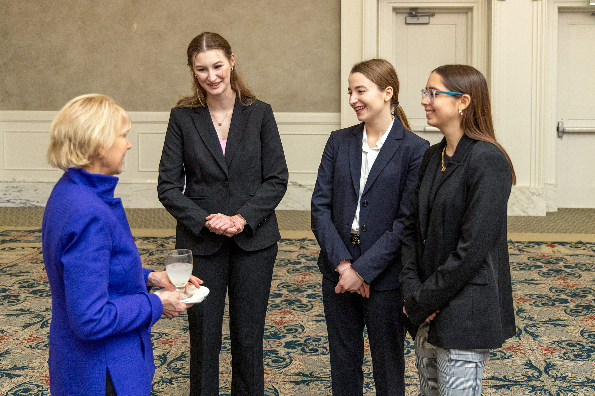 Three students talking to a Board member