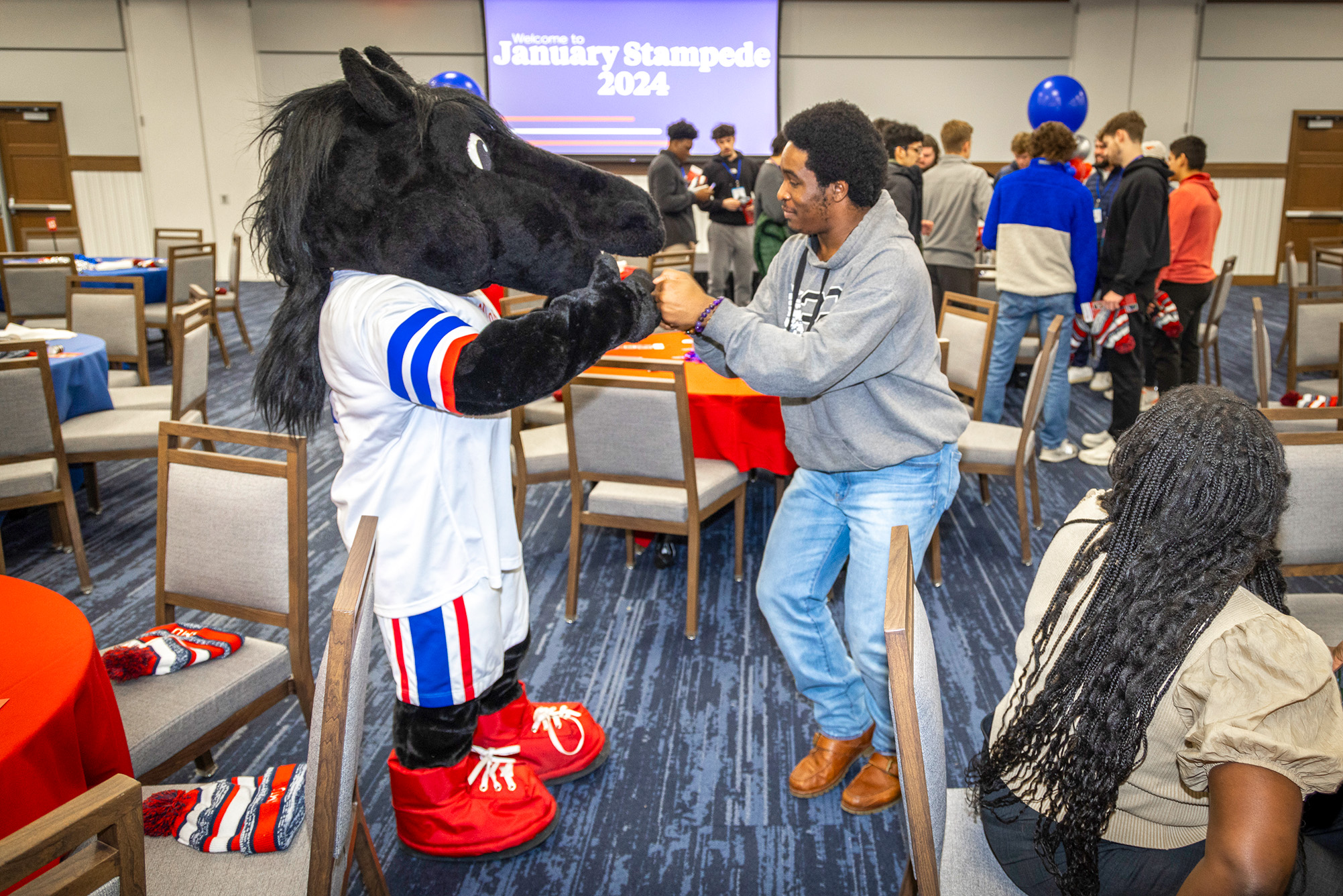 Peruna Mascot having fun with student inside room at Stampede, new student orientation