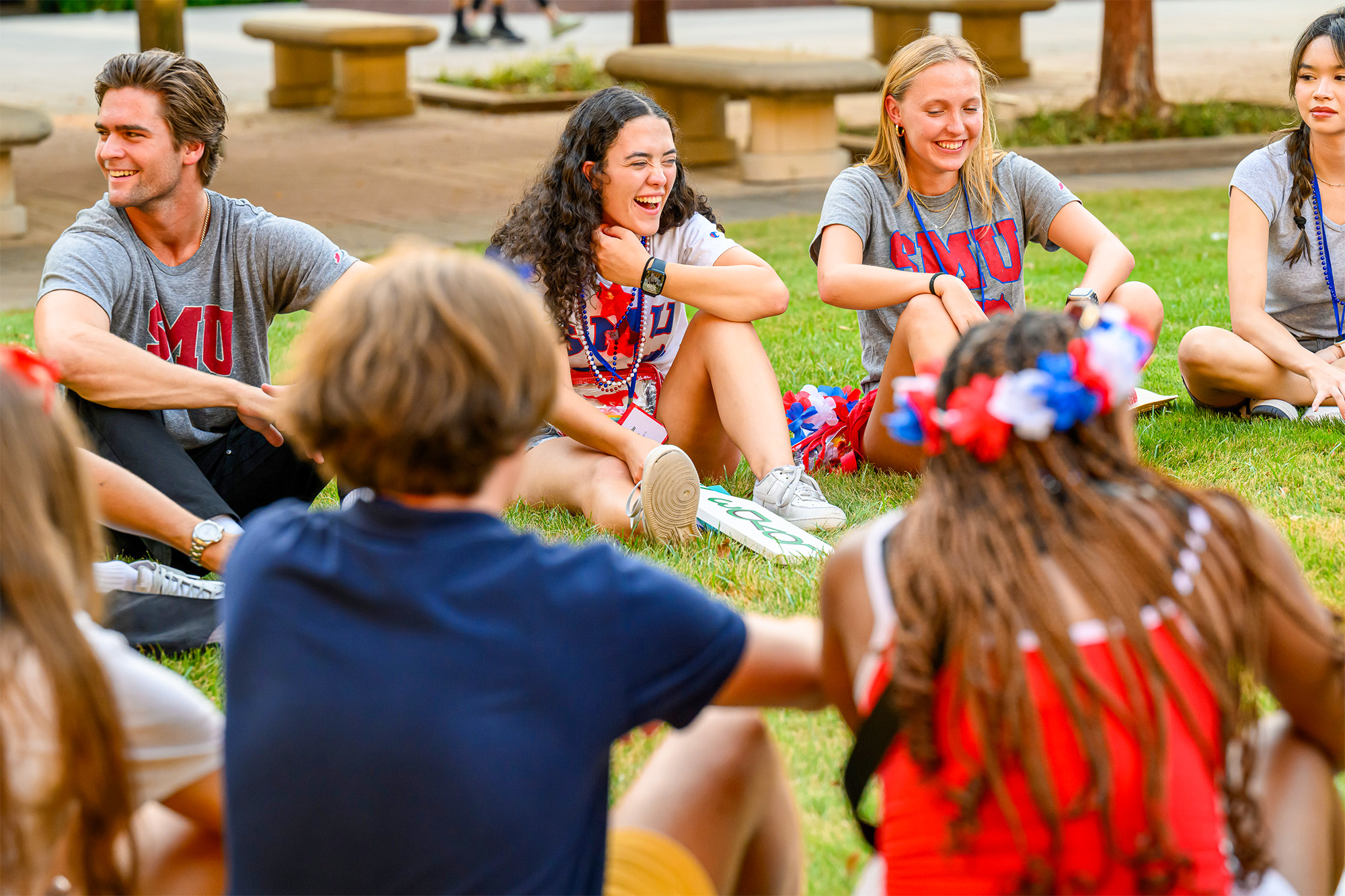 students sitting in circle outside on grass talking and having fun